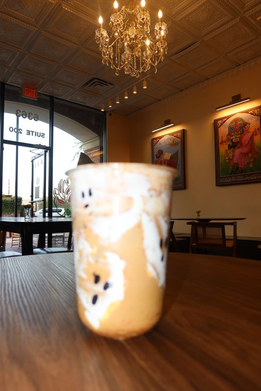 Inside Moharani Coffee House: chandelier, warm walls and framed art