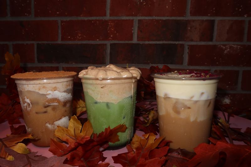 Three iced drinks with foam on a table of autumn leaves